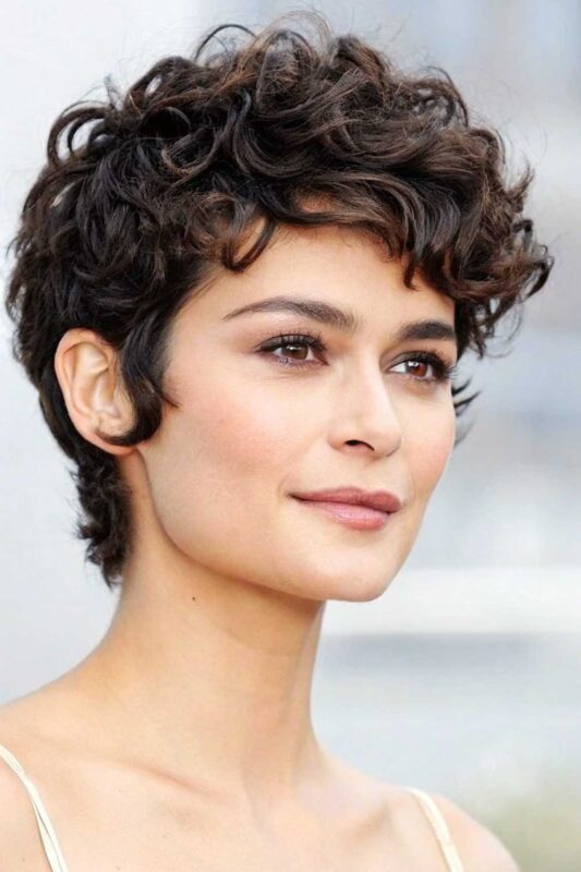 A woman with a modern curly pixie hairstyle.