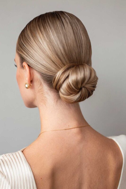 A young woman with low sleek bun hairstyle.
