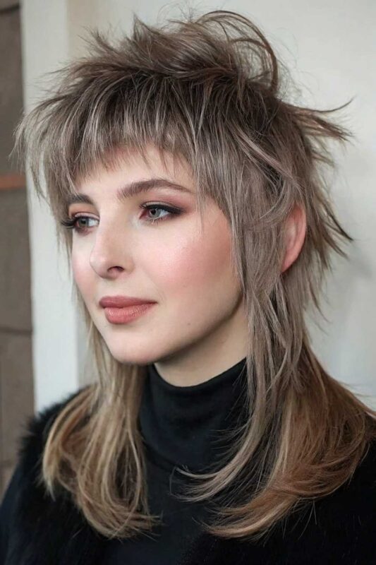 A woman with a modern wolf cut hairstyle.