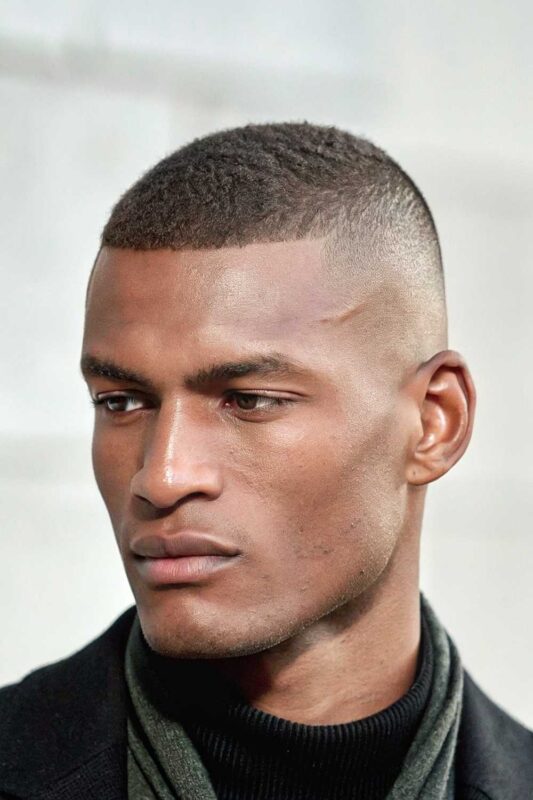 Man with high and tight haircut featuring extremely short sides and slightly longer top with clean, sharp lines.