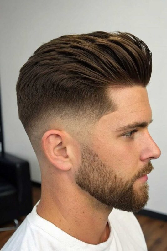 Man with natural fade haircut showing gradual tapering on sides with relaxed texture on top in a casual summer setting.