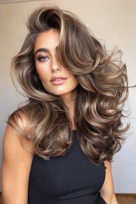 A young woman with bouncy blowout hairstyle.