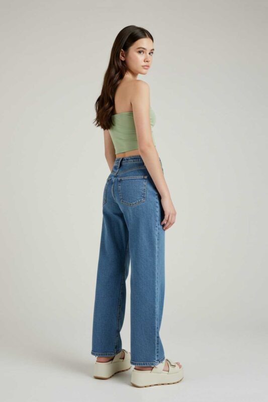 Teen girl in crop top and wide-leg jeans retro summer outfit.