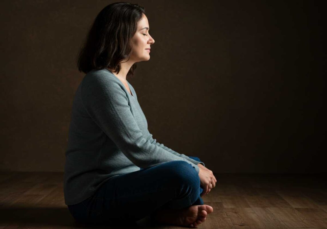 Woman in quiet contemplation with peaceful expression, representing emotional resilience and mindfulness.