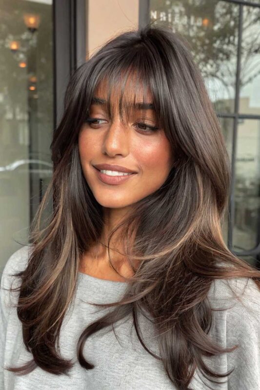 Woman with long blonde hair and soft wispy bangs.