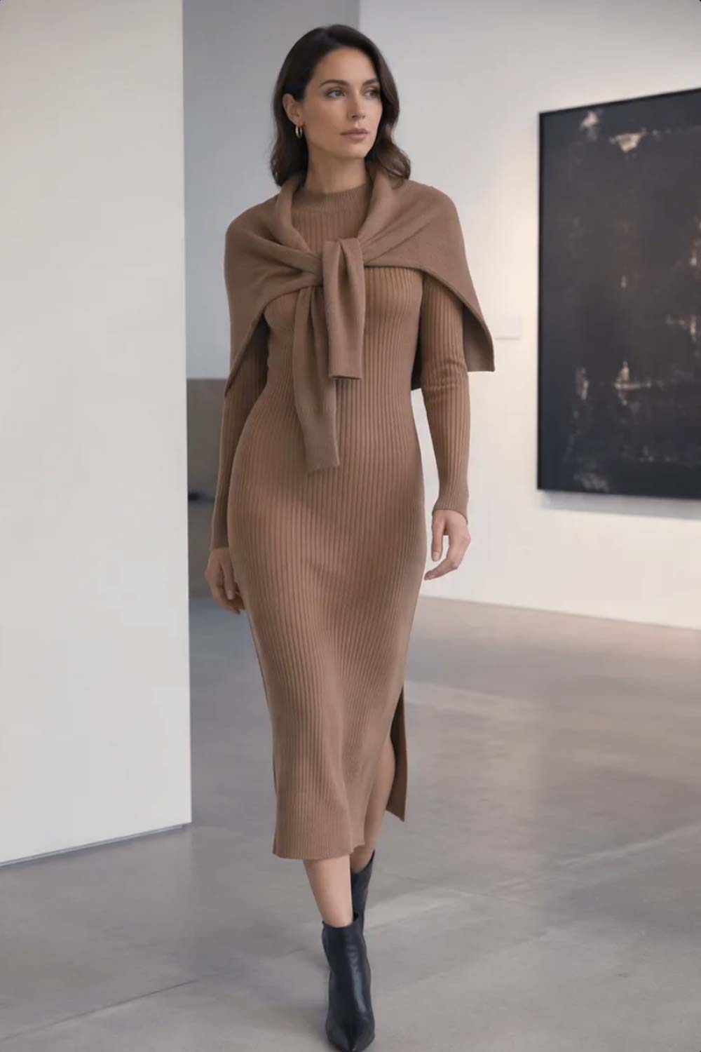 Woman in a camel ribbed-knit midi dress with a matching cardigan draped over the shoulders and black pointed-toe ankle boots for a monochromatic quiet luxury outfit